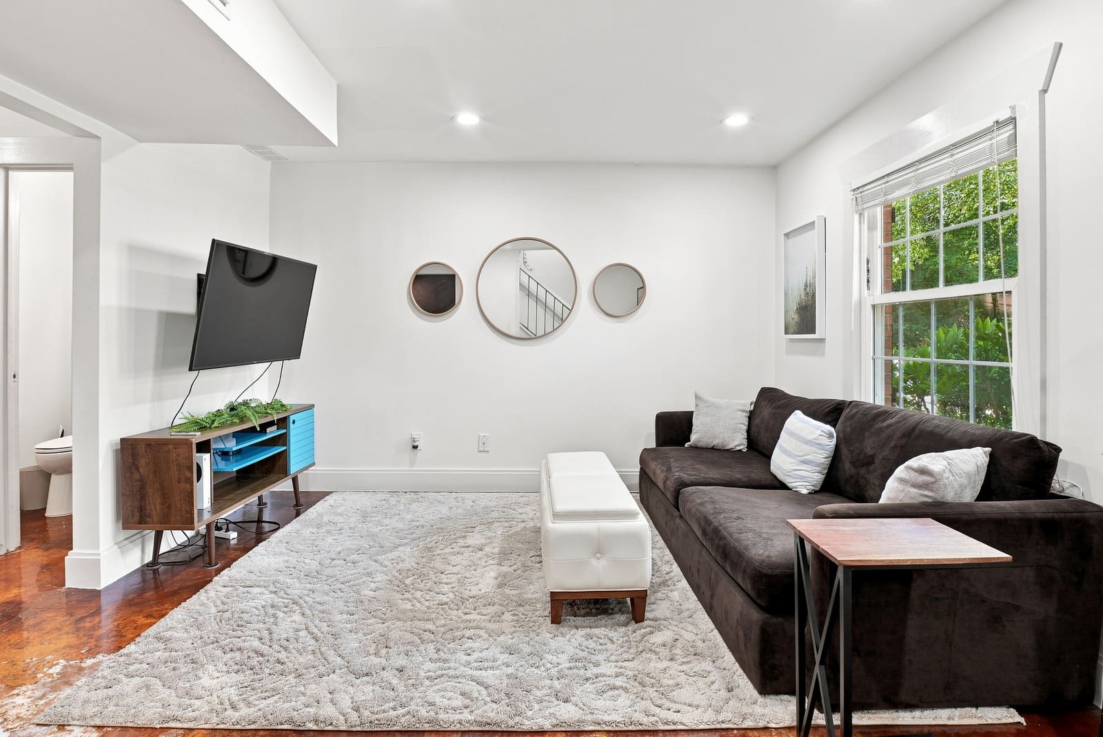 Living room with a sectional sofa, television and large window